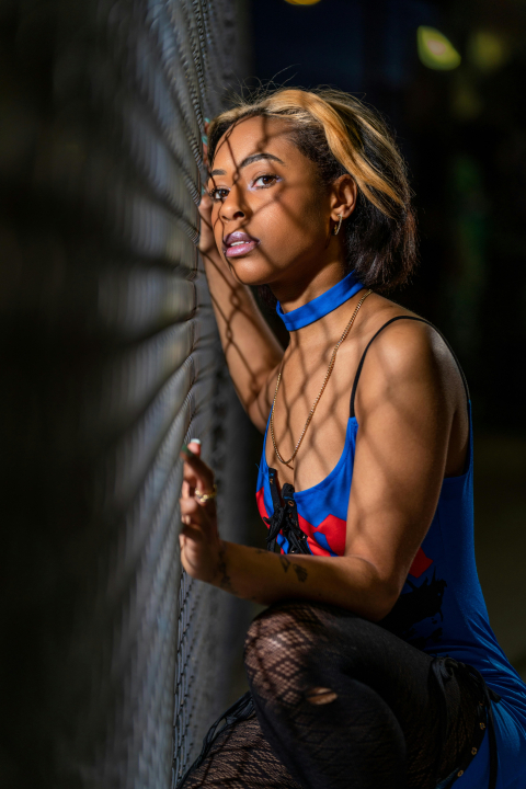 free-photo-of-portrait-of-a-young-woman-leaning-on-a-chainlink-fence